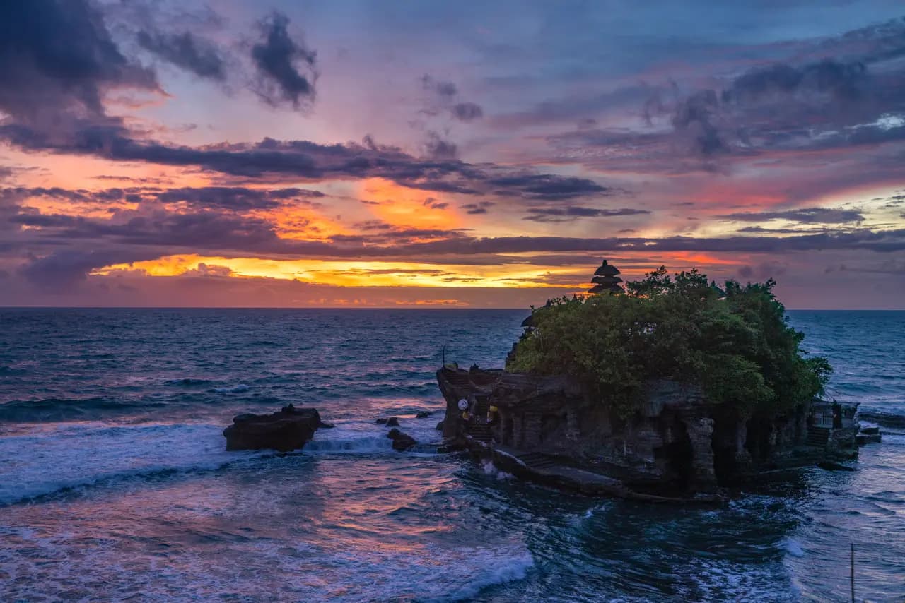 Tanah lot temple in bali at sunset with dramatic colorful clouds over the indian ocean